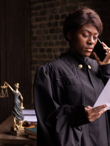 Photo by KATRIN BOLOVTSOVA: https://www.pexels.com/photo/a-judge-reading-a-document-while-having-a-phone-call-6077188/