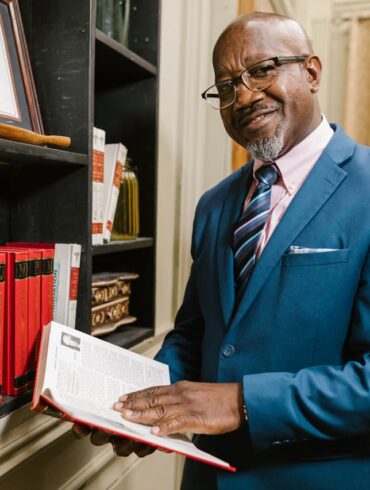 Photo by RDNE Stock project: https://www.pexels.com/photo/a-man-in-blue-suit-jacket-holding-a-book-7841829/
