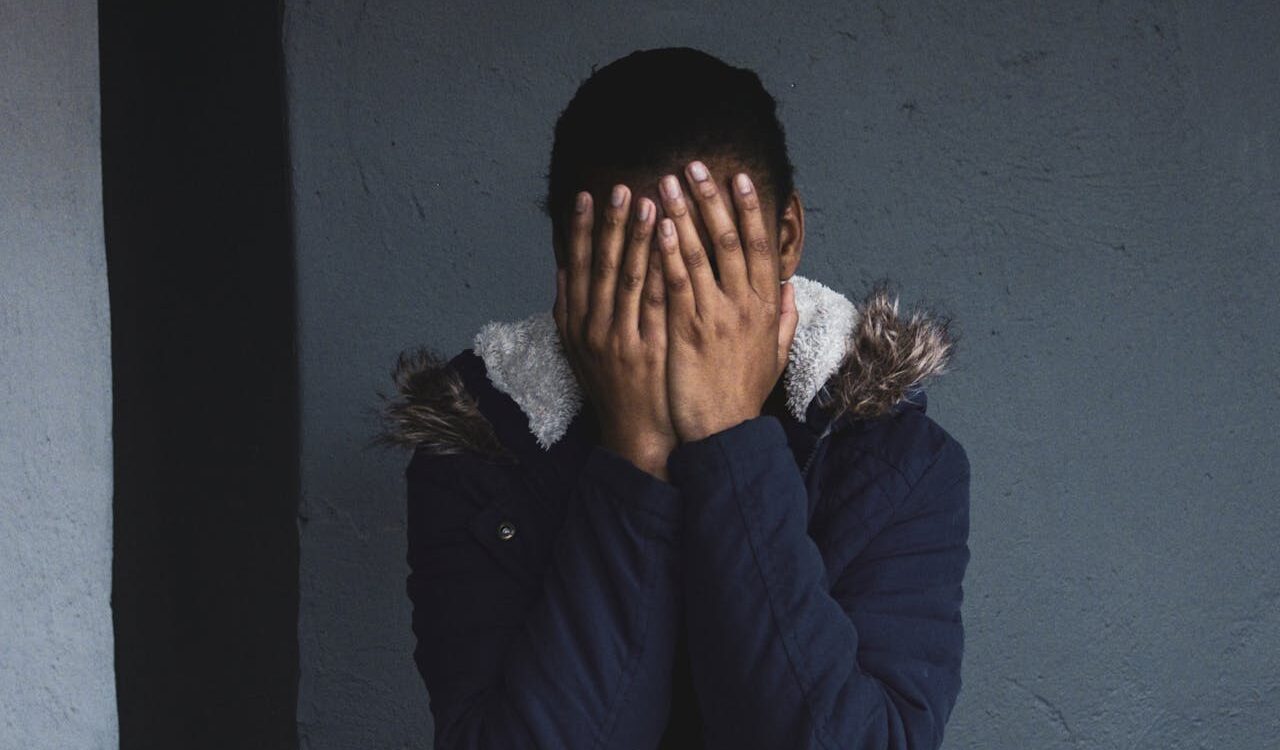 Photo by Justin Thompson: https://www.pexels.com/photo/a-person-wearing-blue-jacket-covering-face-with-her-hands-10369353/