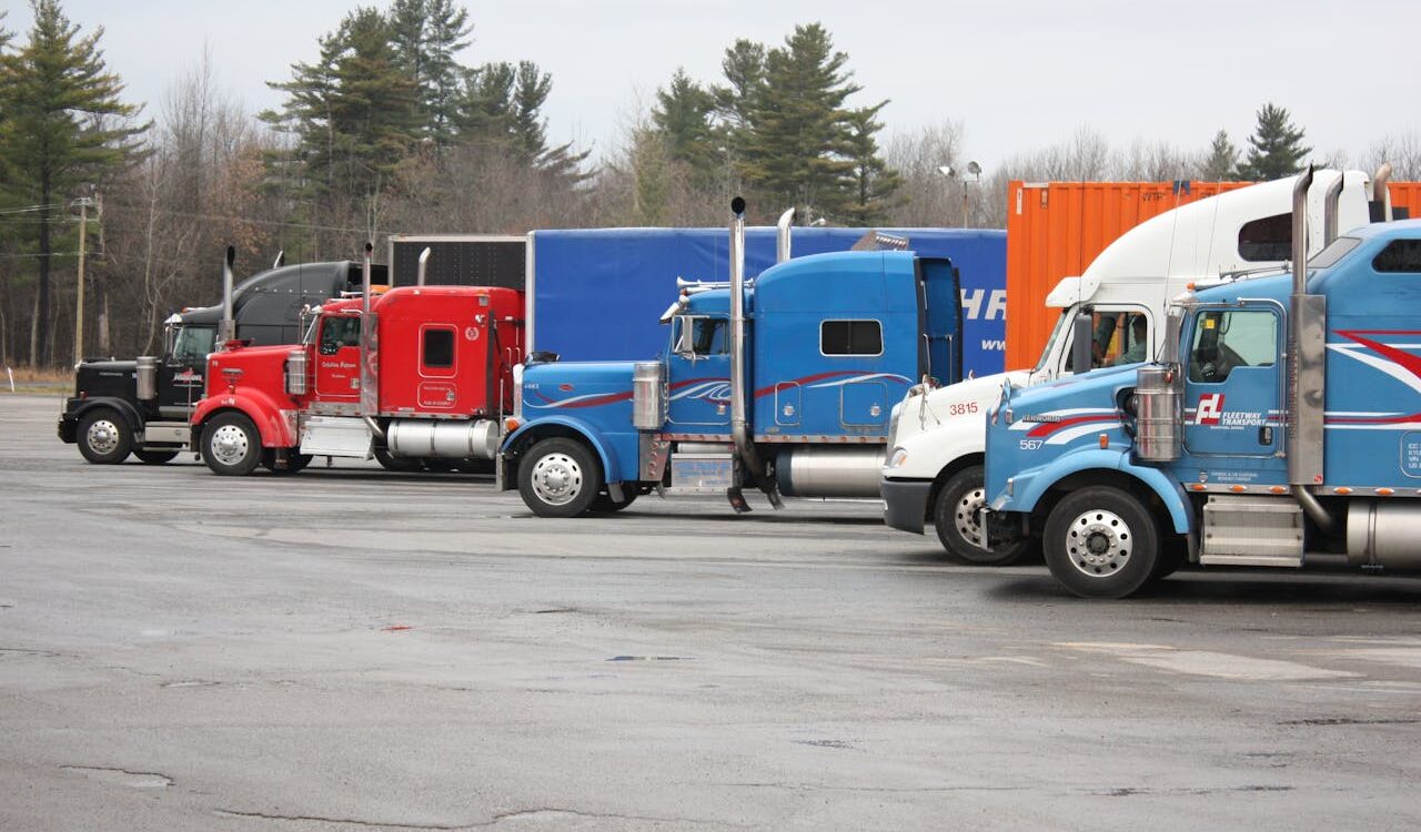 Photo by YL Lew: https://www.pexels.com/photo/colorful-semi-trucks-parked-in-open-lot-35996049/