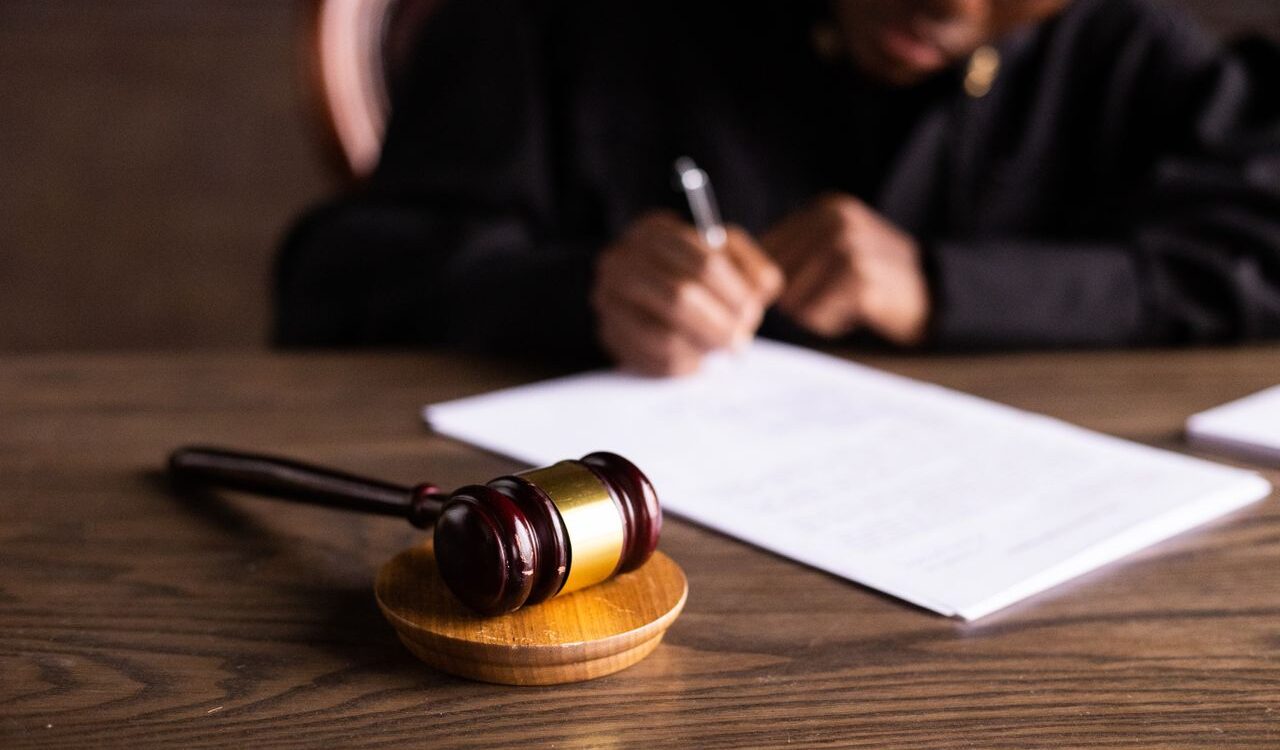 Photo by KATRIN BOLOVTSOVA: https://www.pexels.com/photo/judge-signing-on-the-papers-6077447/