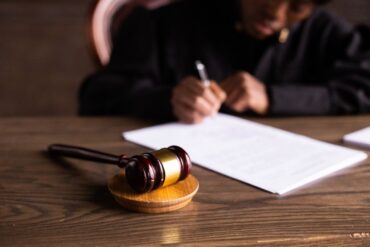 Photo by KATRIN BOLOVTSOVA: https://www.pexels.com/photo/judge-signing-on-the-papers-6077447/